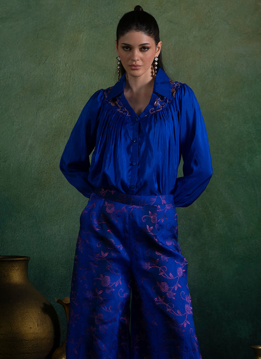 Woman wearing royal blue brocade fabric blouse and pant set
